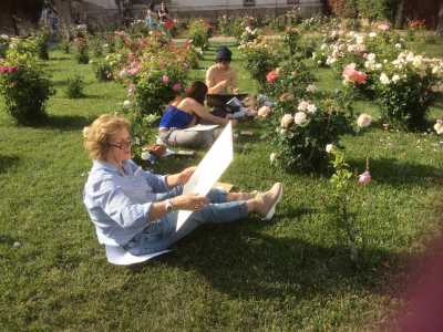Tre studenti all'opera circondati dal verde della villa